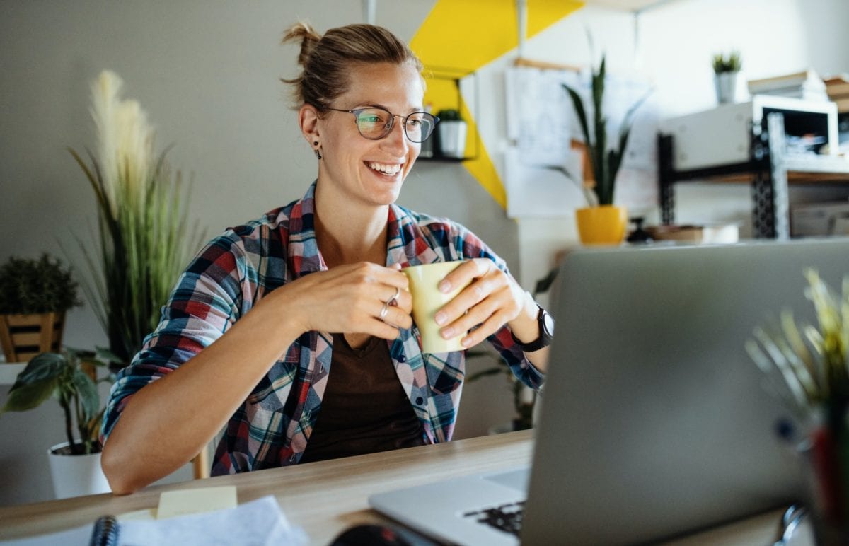 Woman smiling at her laptop during lockdown